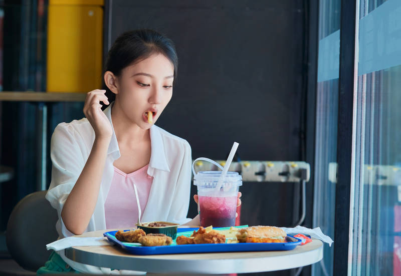 在商场快餐厅大吃特吃的中国可爱少女人像图片