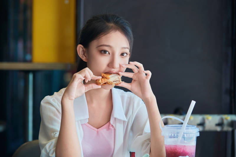 在商场快餐厅大吃特吃的中国可爱少女人像图片