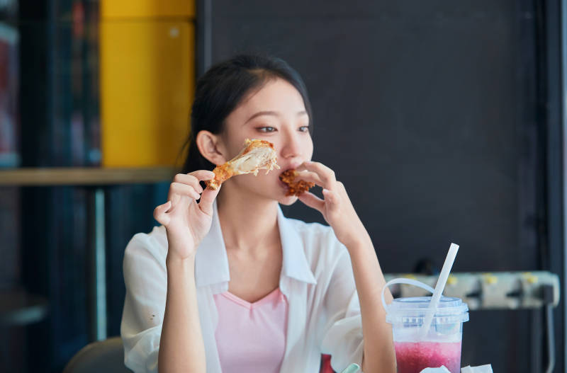 在商场快餐厅大吃特吃的中国可爱少女人像图片