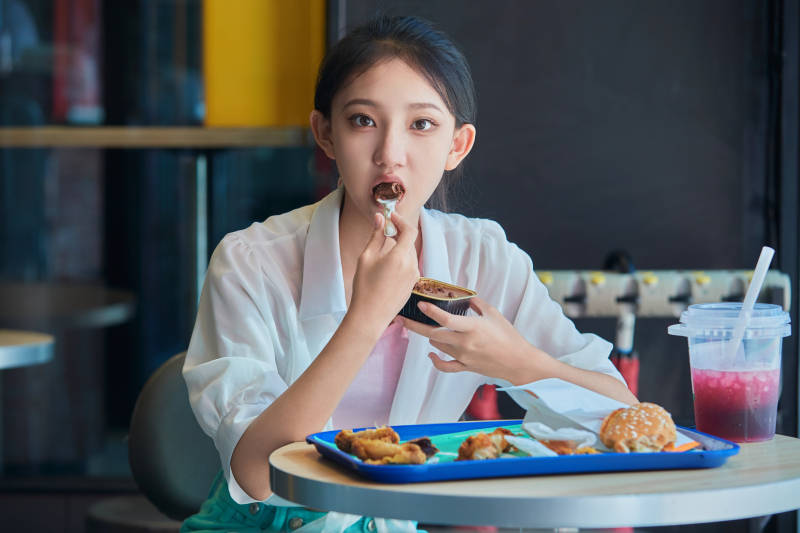 在商场快餐厅大吃特吃的中国可爱少女人像图片