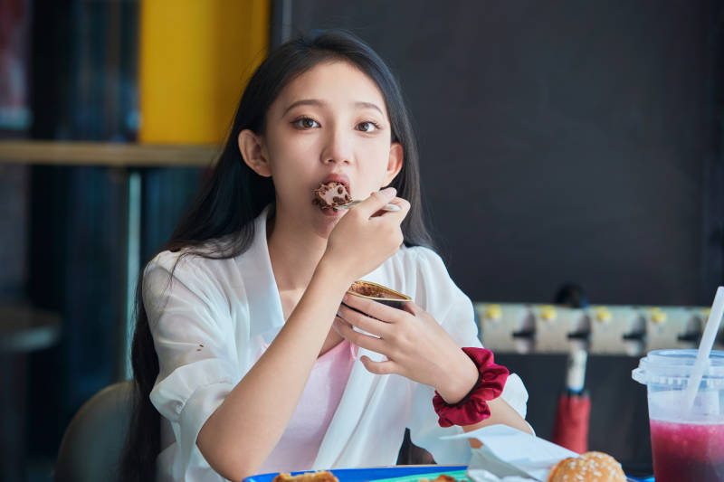 在商场快餐厅大吃特吃的中国可爱少女人像图片