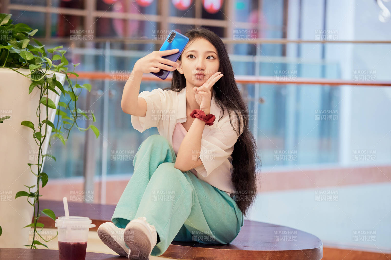 假日在商场休息区用手机自拍的中国少女图片