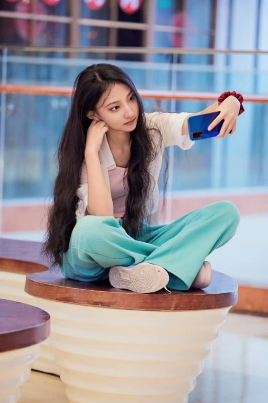 假日在商场休息区用手机自拍的中国少女图片