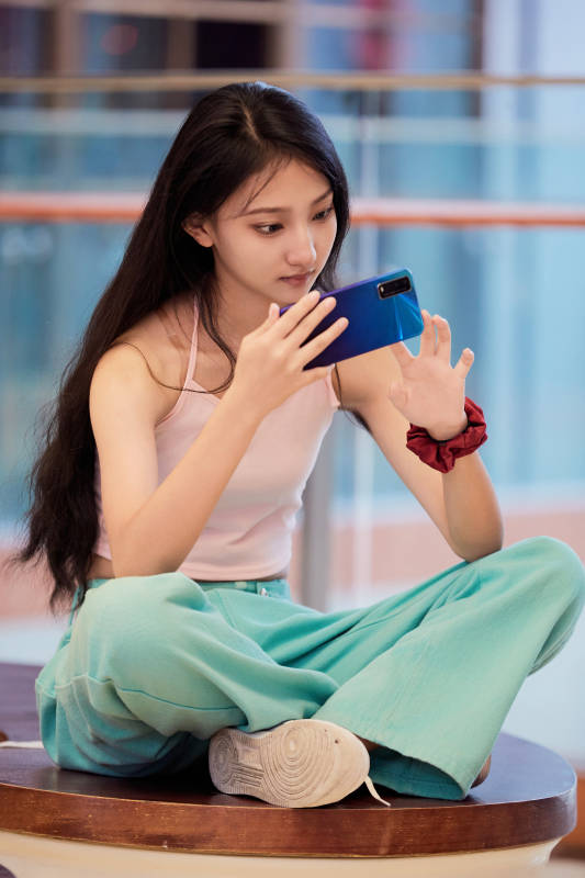 假日在商场休息区用手机自拍的中国少女图片