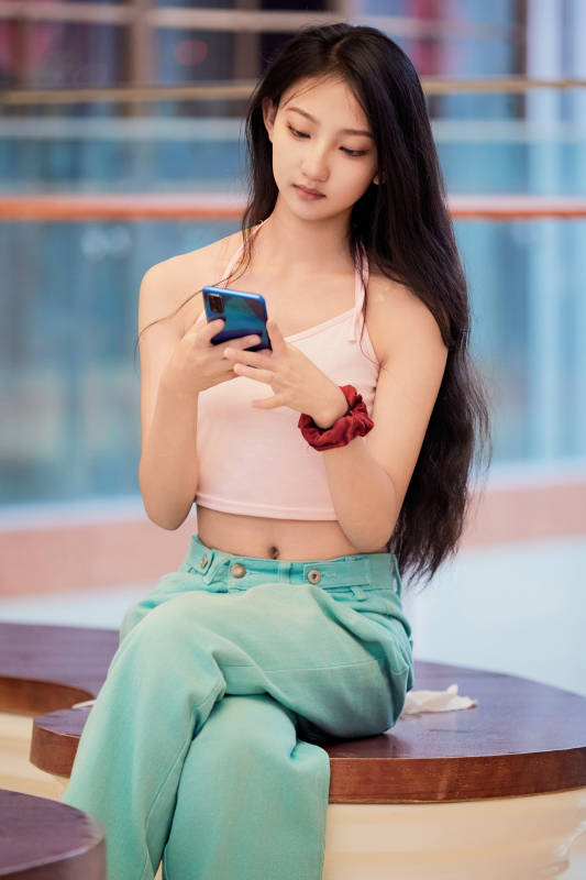 假日在商场休息区用手机自拍的中国少女图片