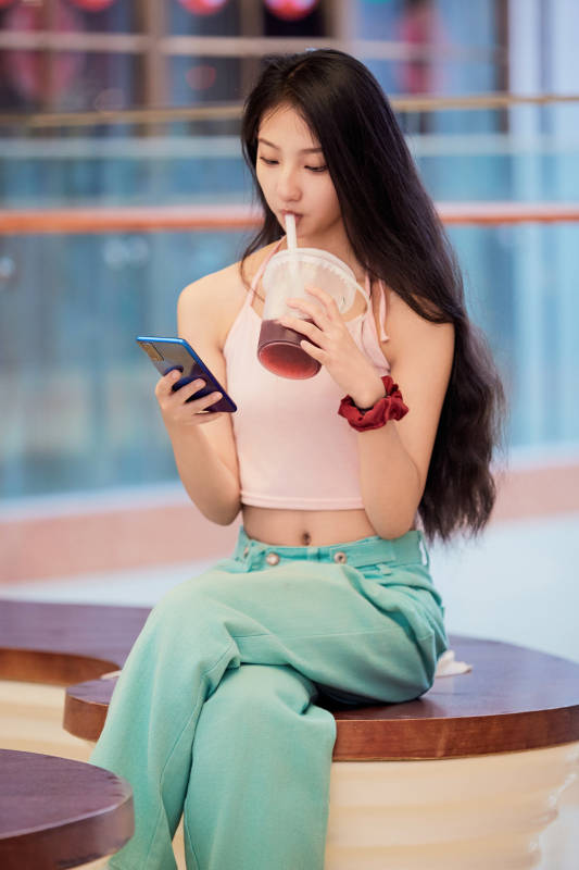 假日在商场休息区用手机自拍的中国少女图片