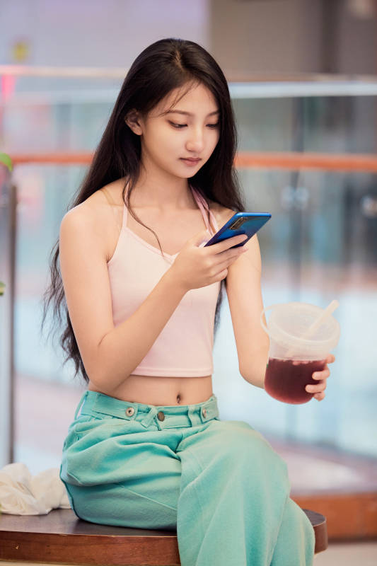 假日在商场休息区用手机自拍的中国少女图片