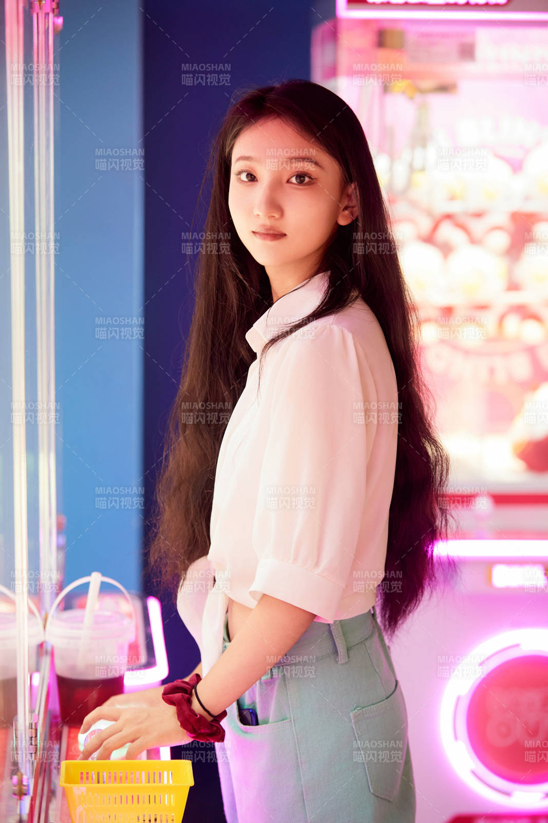 在电子游戏娱乐城玩抓娃娃机的时尚少女图片