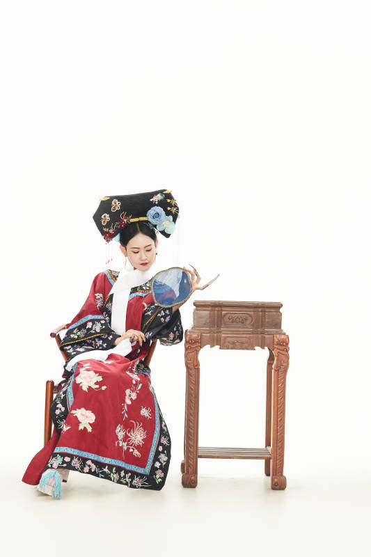 白色背景下穿着中国清朝宫廷服饰的少女图片