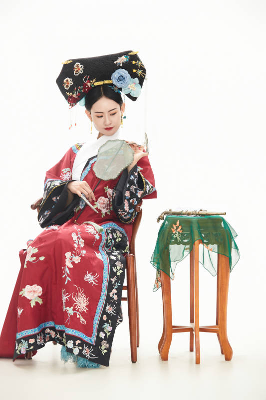 白色背景下穿着中国清朝宫廷服饰的少女图片