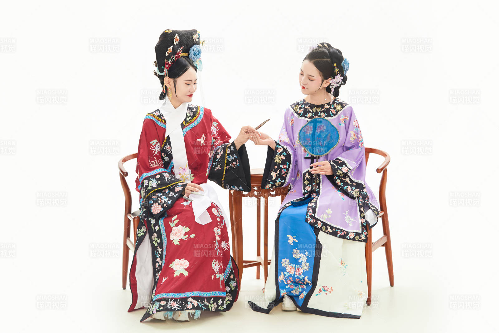 白色背景下穿着中国清朝服饰的两名少女图片