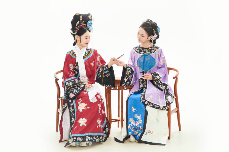 白色背景下穿着中国清朝服饰的两名少女图片