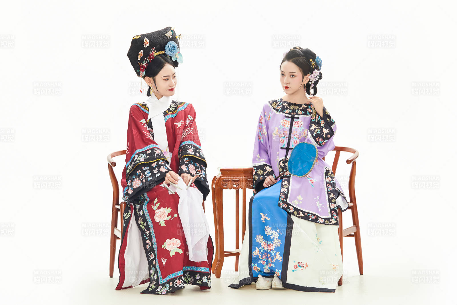 白色背景下穿着中国清朝服饰的两名少女图片