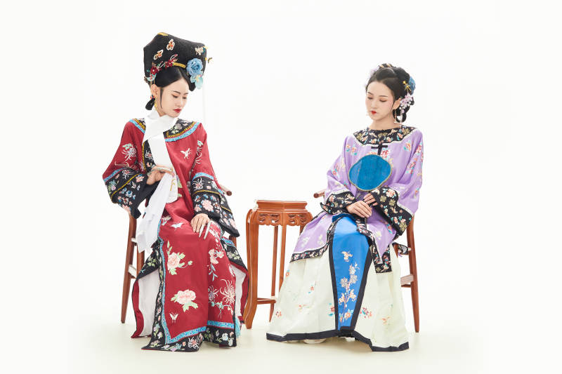 白色背景下穿着中国清朝服饰的两名少女图片