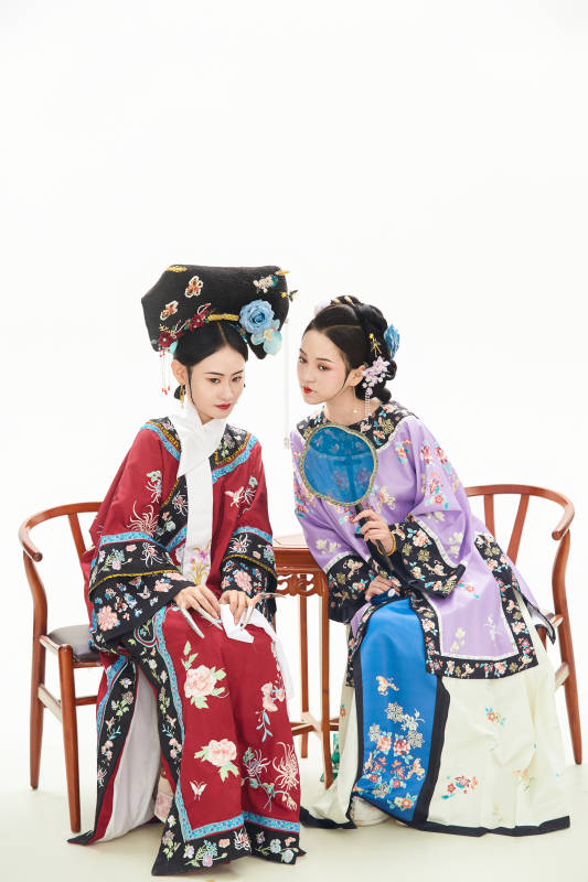白色背景下穿着中国清朝服饰的两名少女图片
