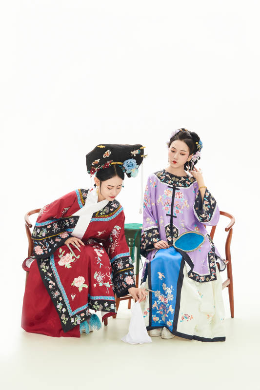 白色背景下穿着中国清朝服饰的两名少女图片