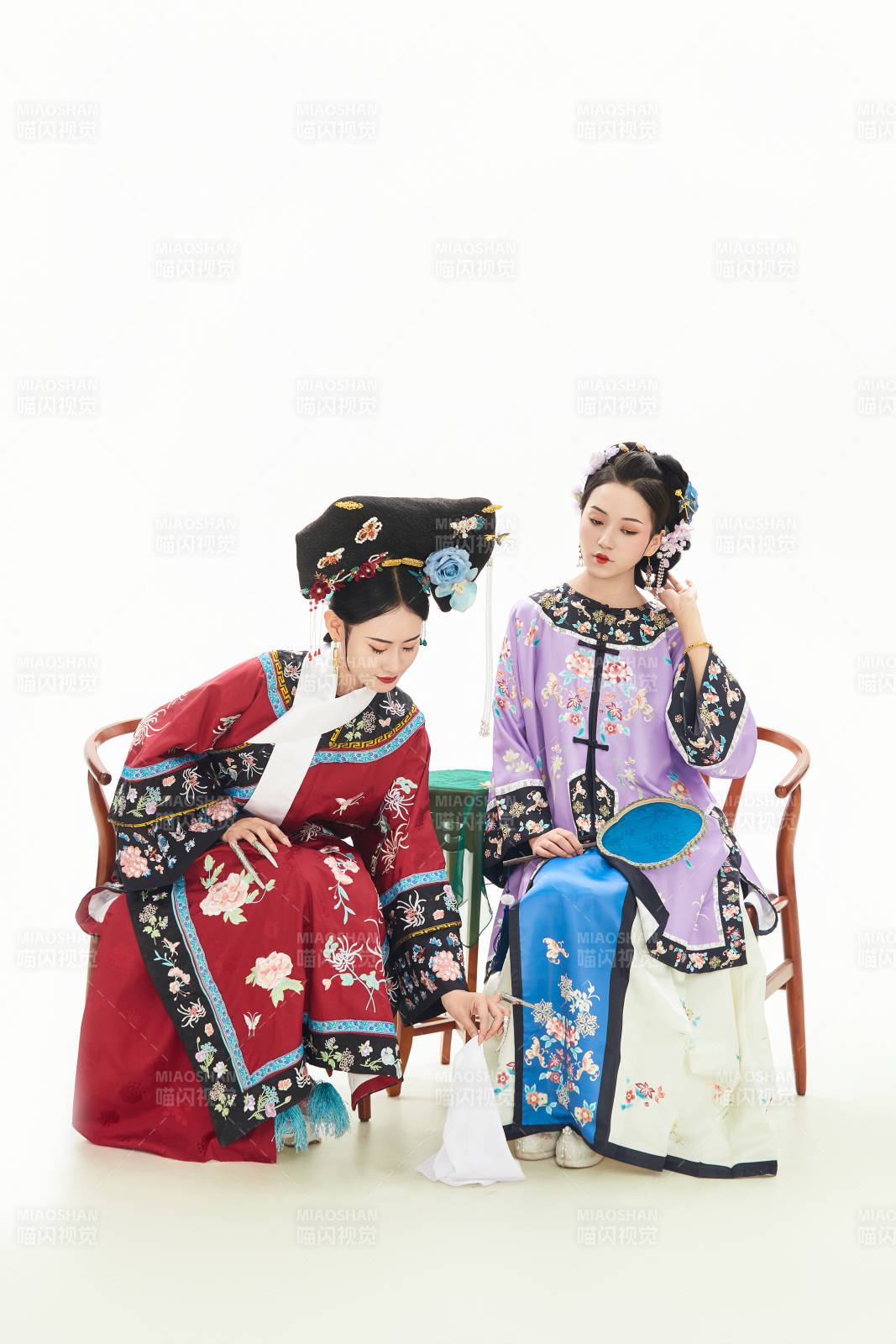 白色背景下穿着中国清朝服饰的两名少女图片