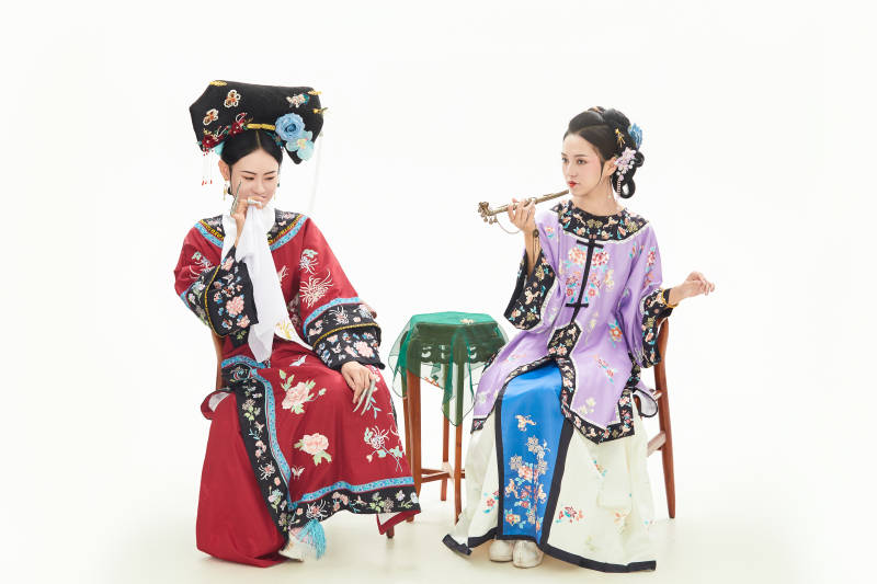 白色背景下穿着中国清朝服饰的两名少女图片