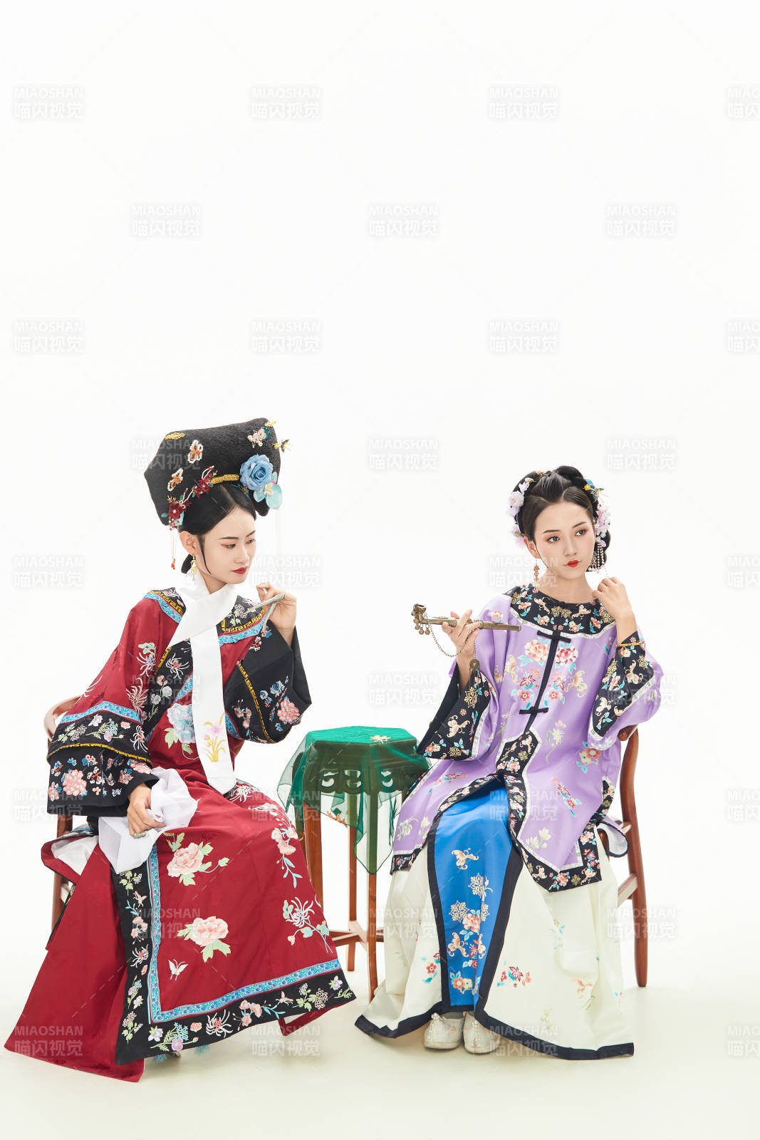 白色背景下穿着中国清朝服饰的两名少女图片