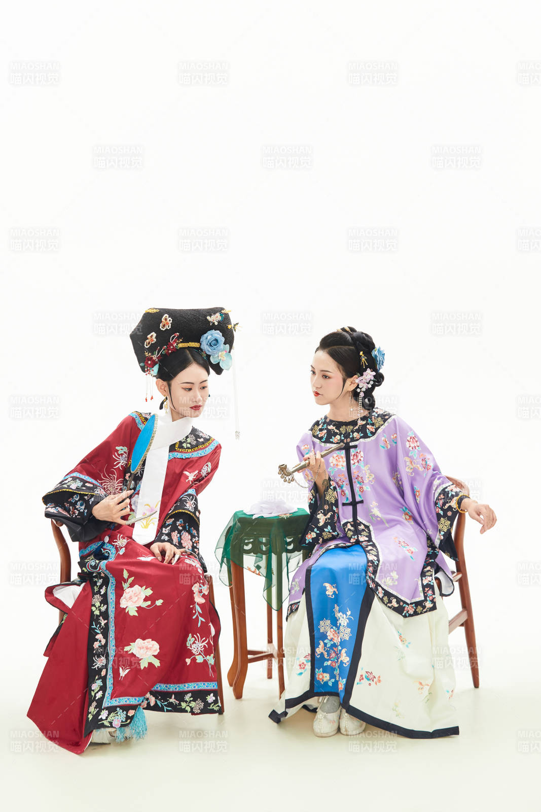 白色背景下穿着中国清朝服饰的两名少女图片
