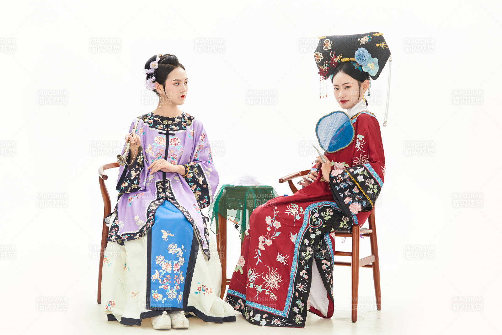 白色背景下穿着中国清朝服饰的两名少女图片