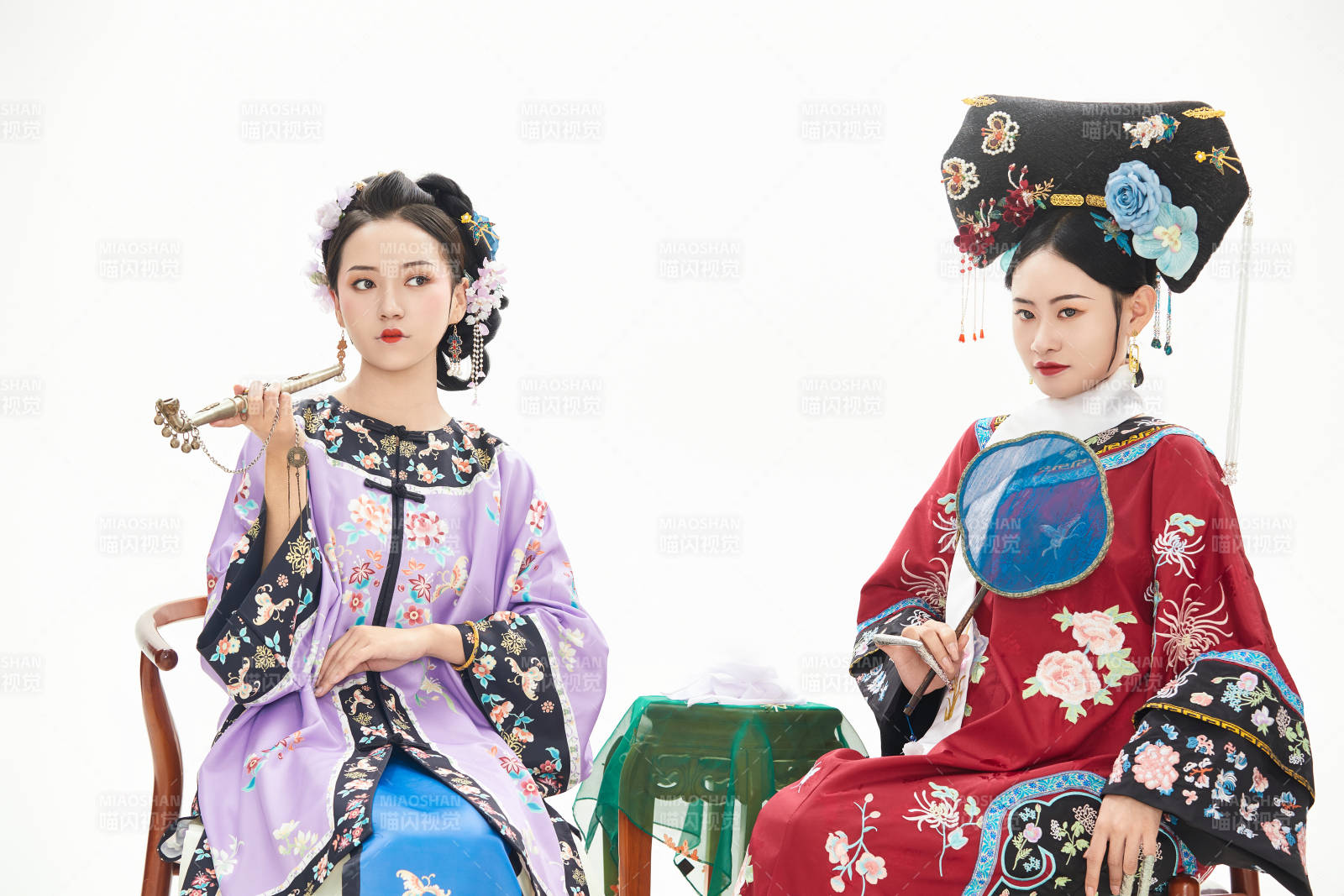 白色背景下穿着中国清朝服饰的两名少女图片