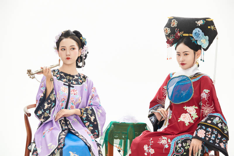 白色背景下穿着中国清朝服饰的两名少女图片