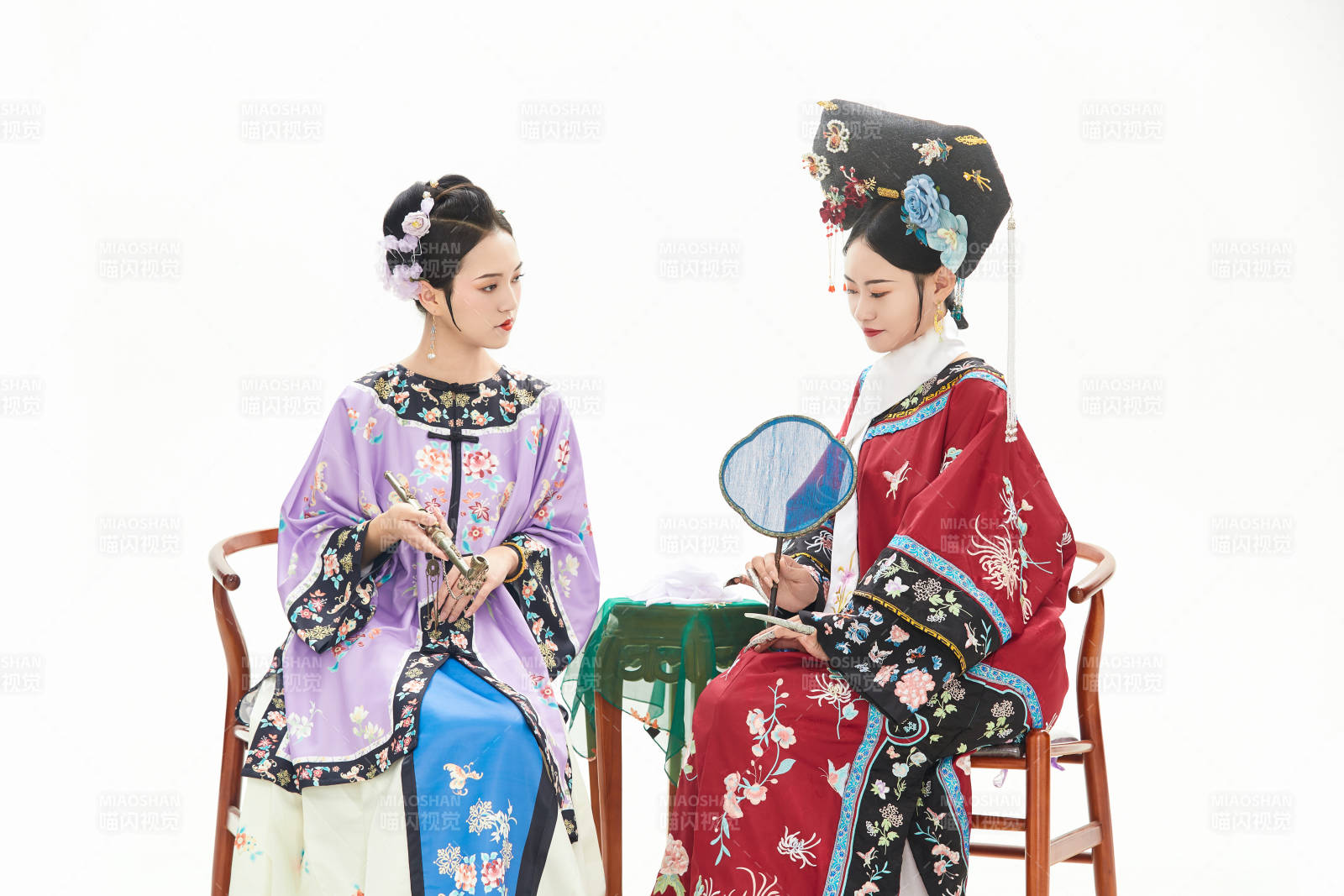 白色背景下穿着中国清朝服饰的两名少女图片