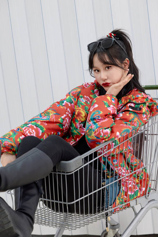 坐在商场超市购物车拍照玩乐的亚洲美女图片