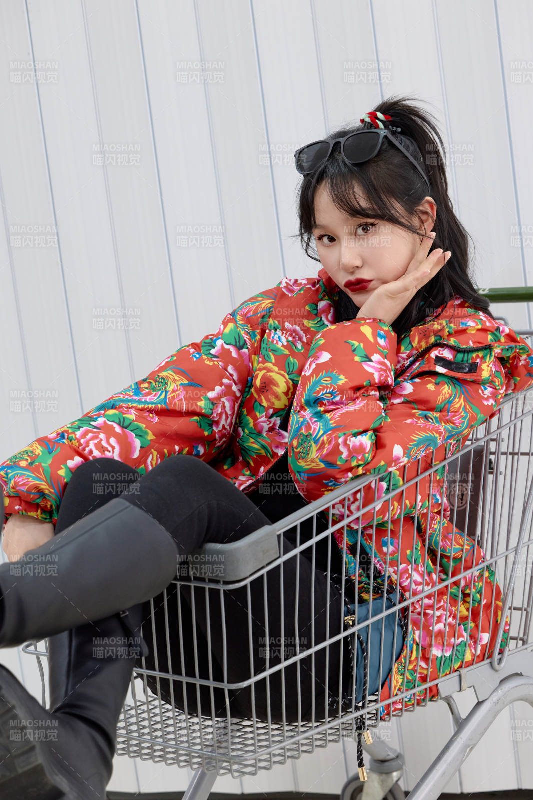 坐在商场超市购物车拍照玩乐的亚洲美女图片