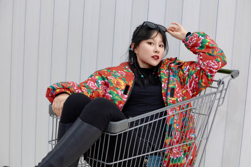 坐在商场超市购物车拍照玩乐的亚洲美女图片