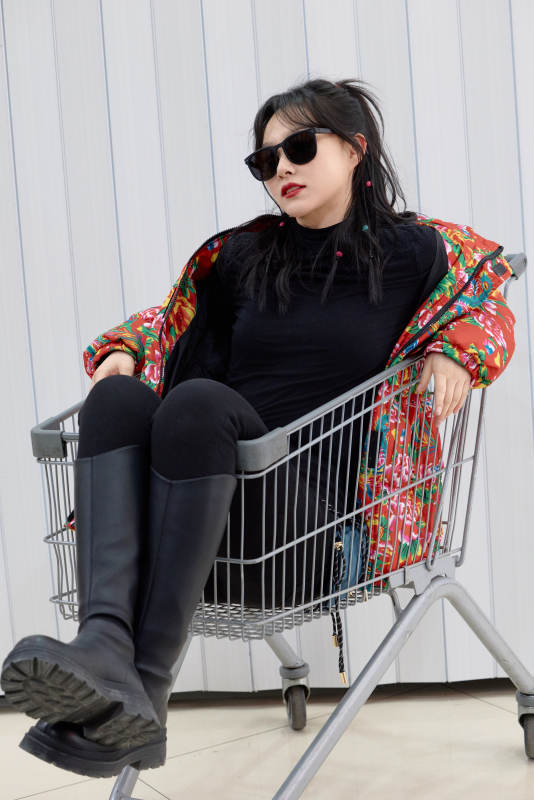 坐在商场超市购物车拍照玩乐的亚洲美女图片