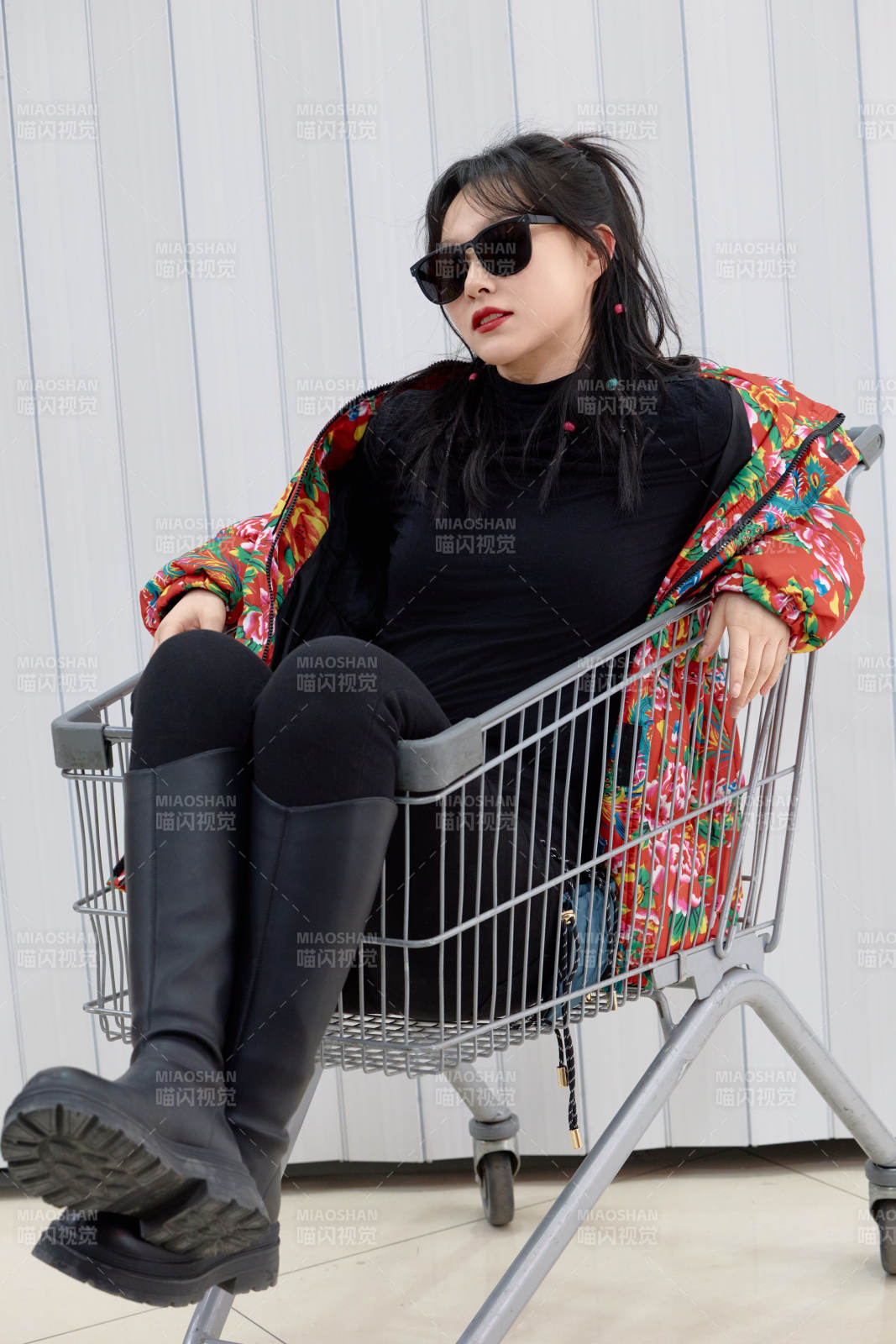 坐在商场超市购物车拍照玩乐的亚洲美女图片