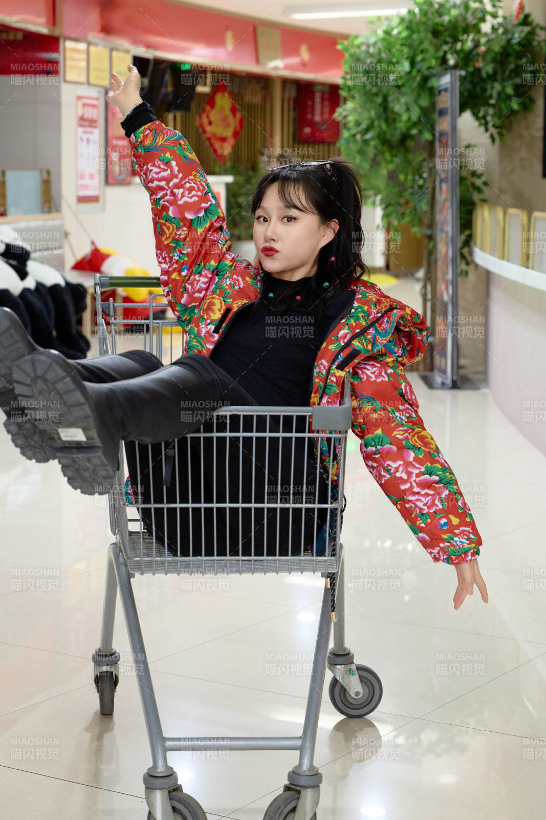 坐在商场超市购物车拍照玩乐的亚洲美女图片