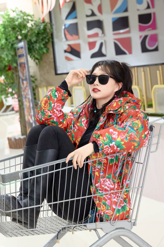 坐在商场超市购物车拍照玩乐的亚洲美女图片