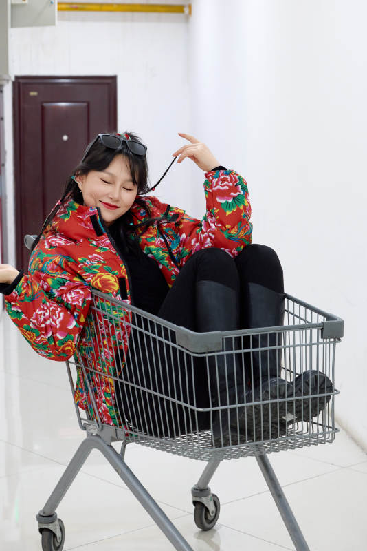 坐在商场超市购物车拍照玩乐的亚洲美女图片