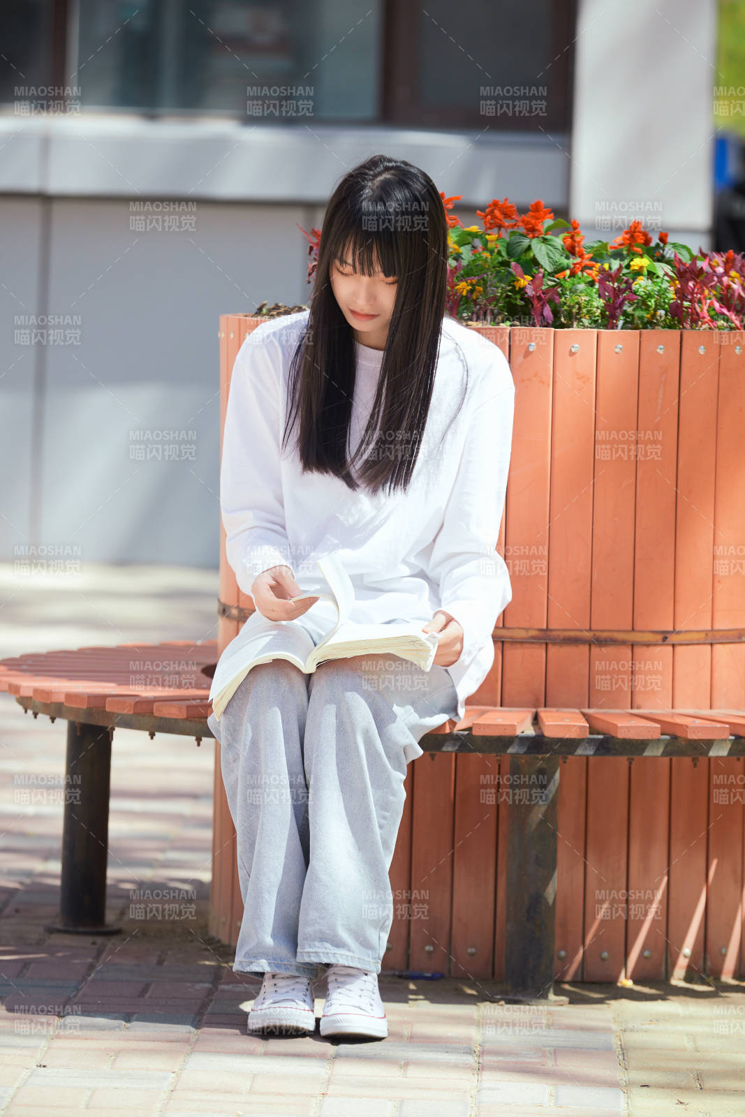 户外校园里读书学习的女大学生图片