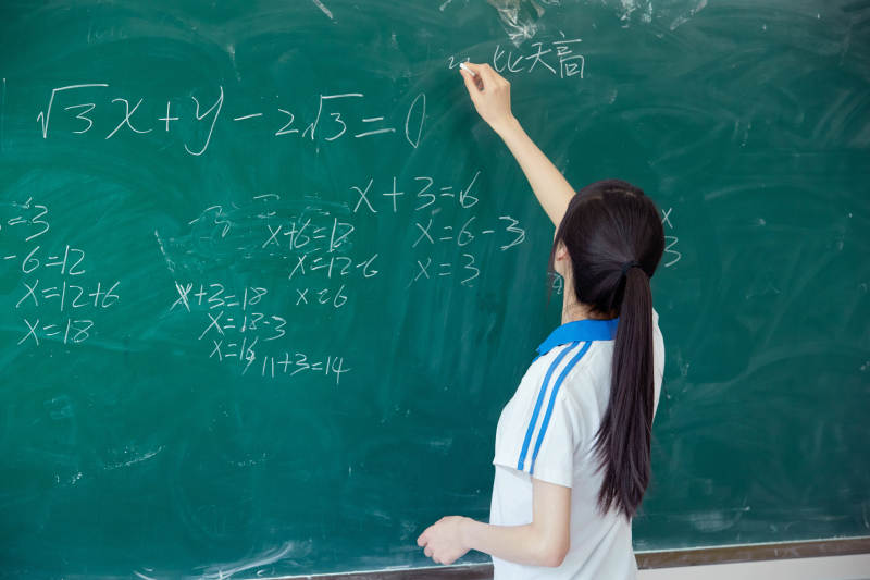 上课时在教室黑板解答数学习题的高中生图片
