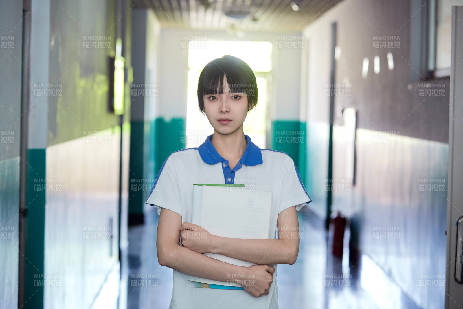 学校走廊里抱着书本的女高中生图片