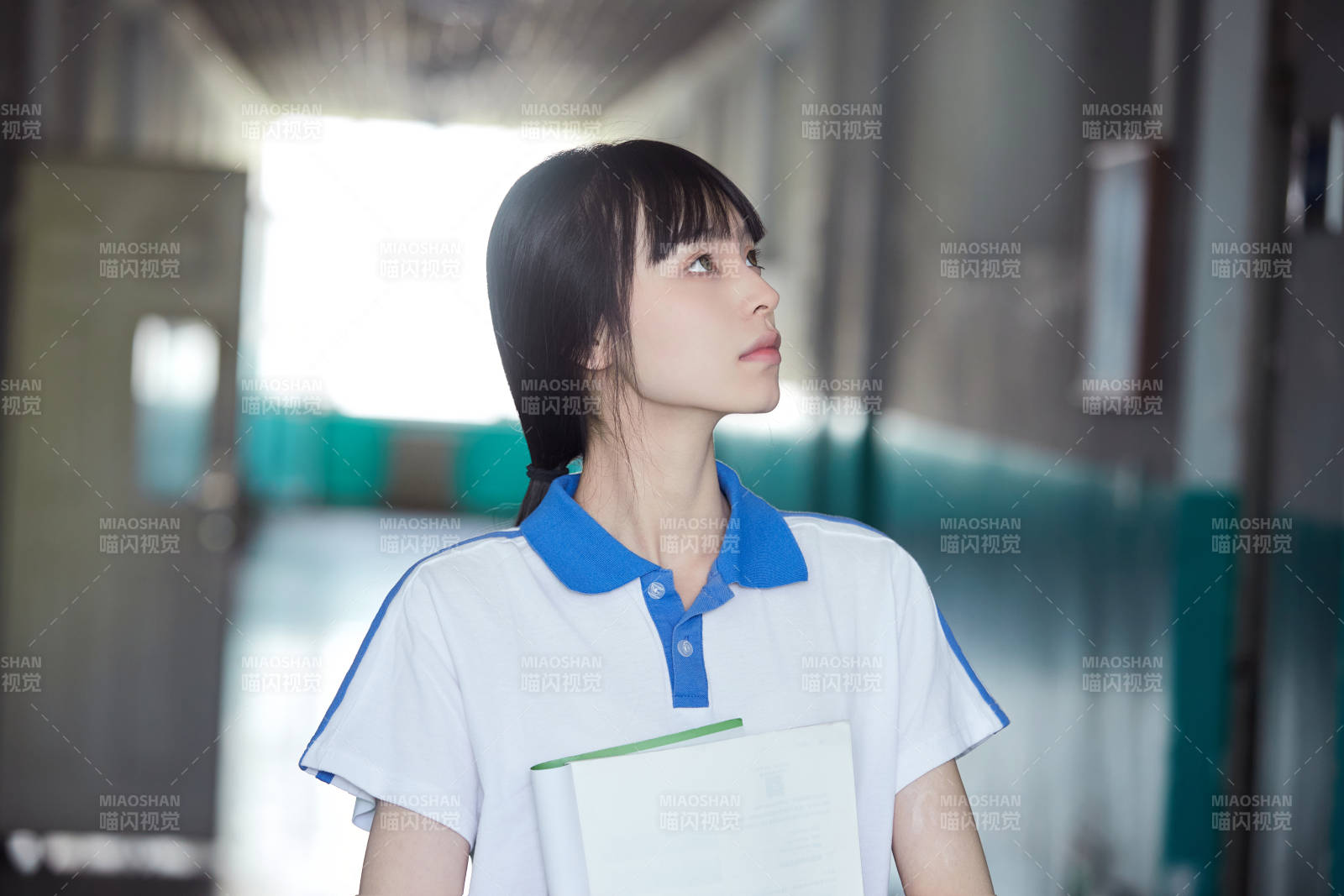 学校走廊里抱着书本的女高中生图片