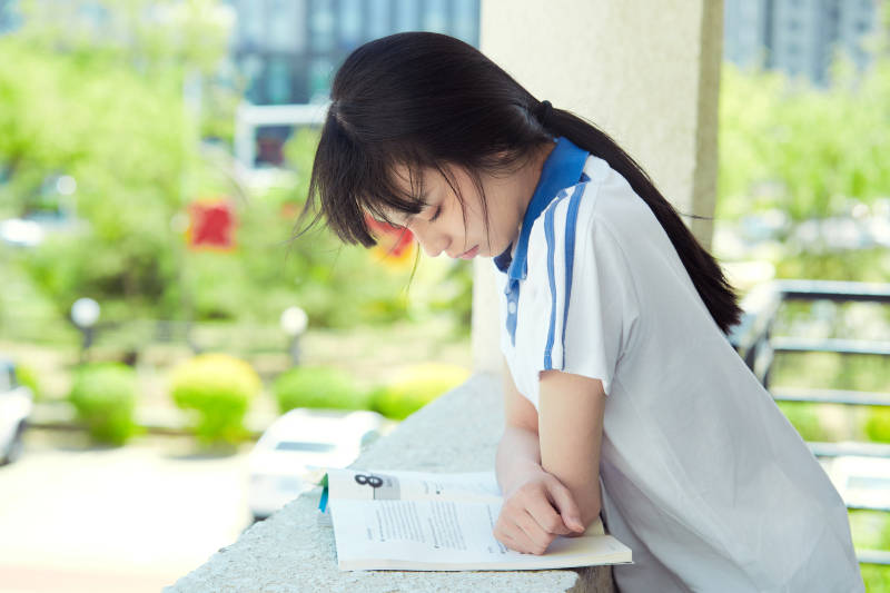 在学校教学楼阳台复习看书的高中生图片