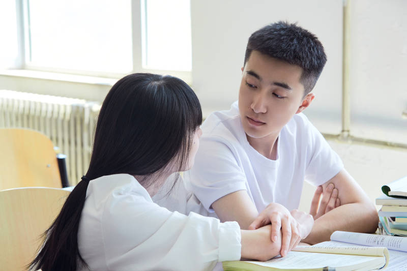 大学自习室相互依偎的青年情侣图片