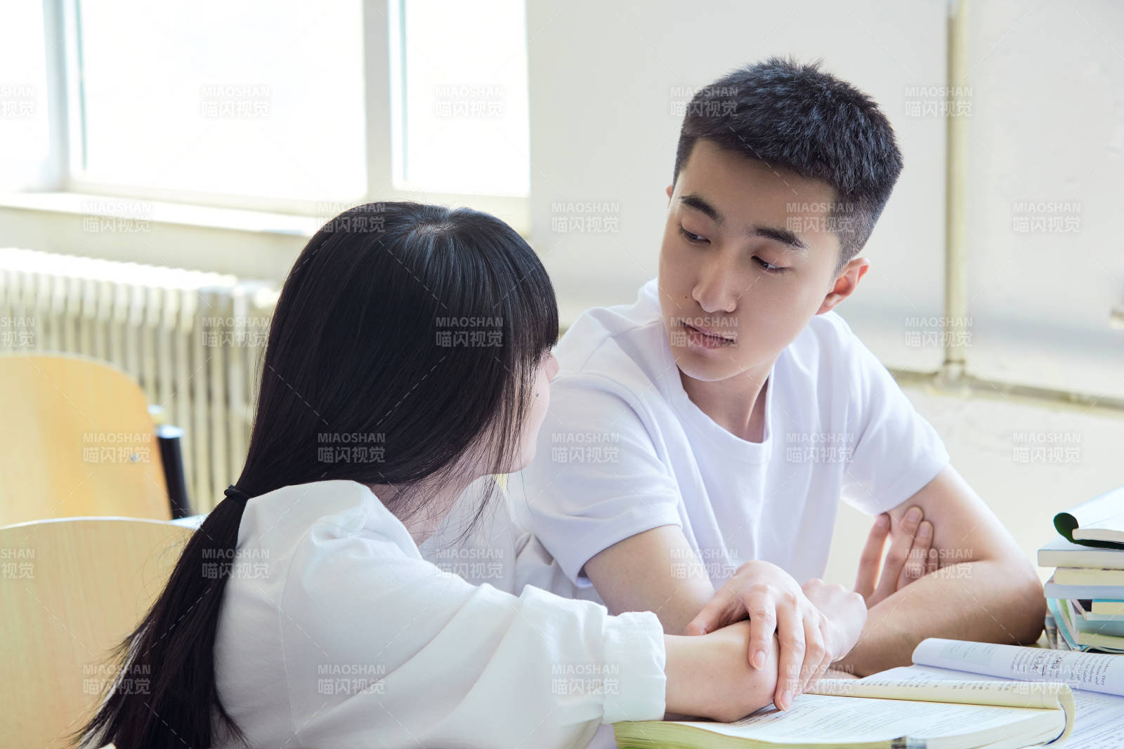 大学自习室相互依偎的青年情侣图片