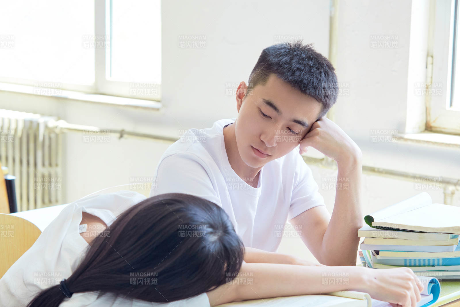 大学自习室相互依偎的青年情侣图片