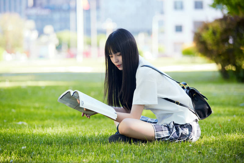 在户外草坪看书学习的女生图片