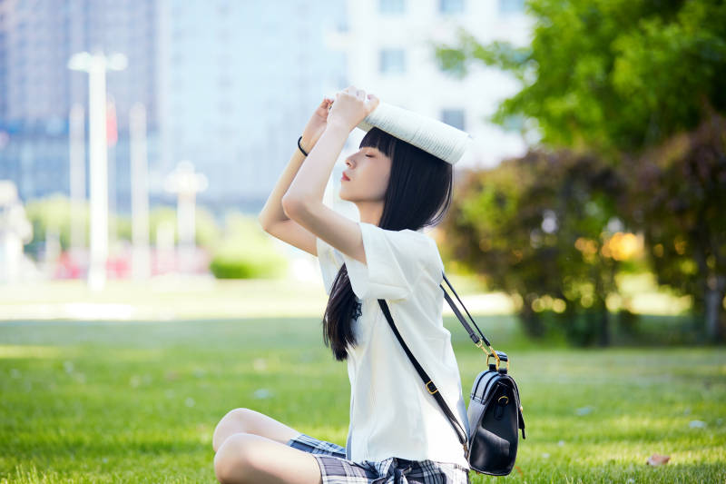 在户外草坪看书学习的女生图片