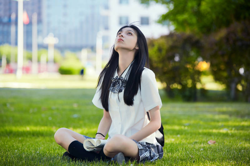 在户外草坪看书学习的女生图片