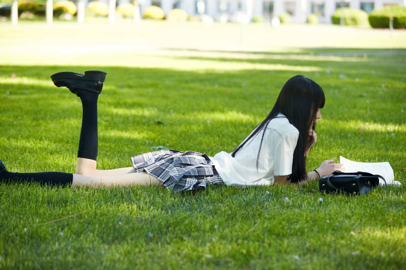 在户外草坪看书学习的女生图片