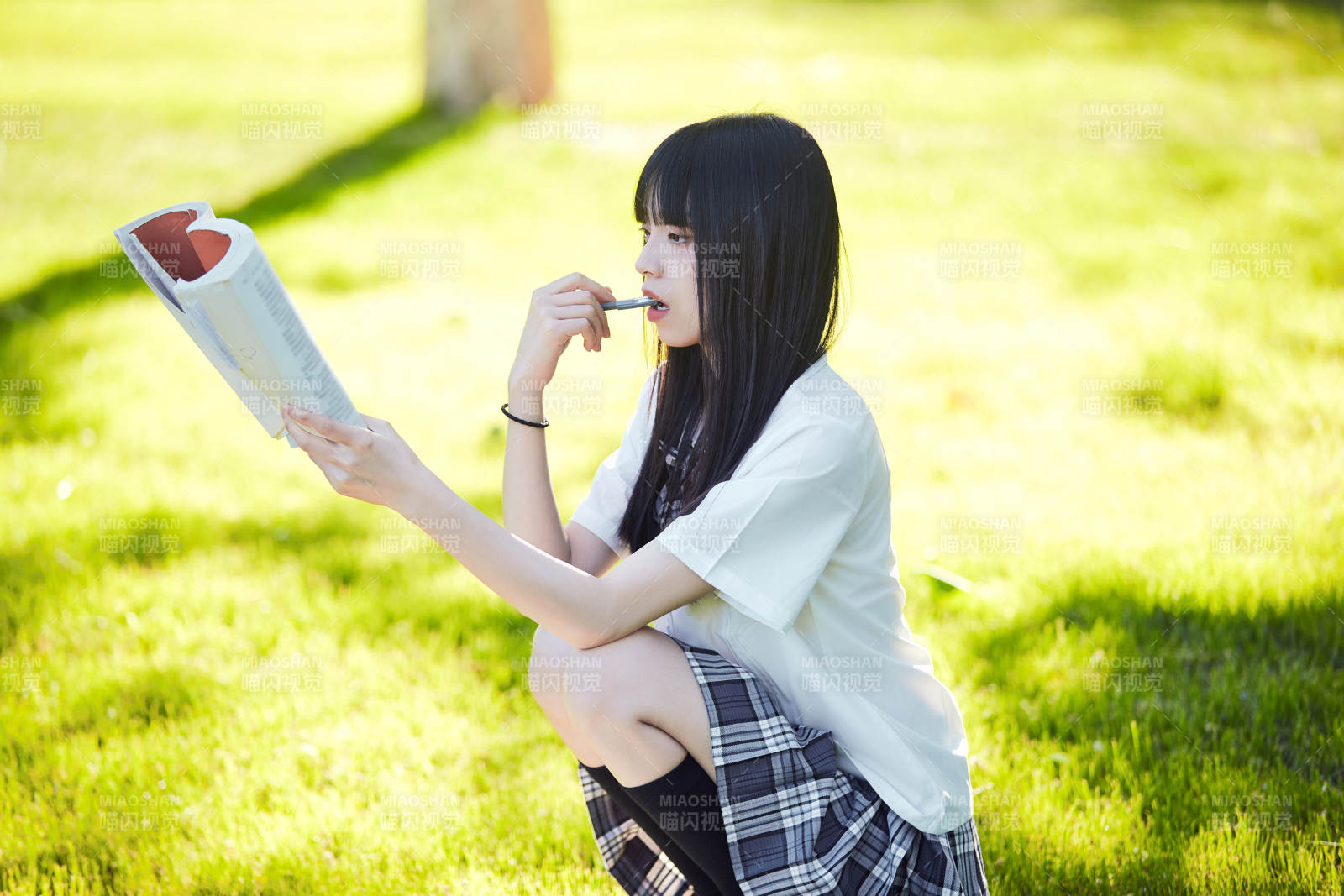 在户外草坪看书学习的女生图片