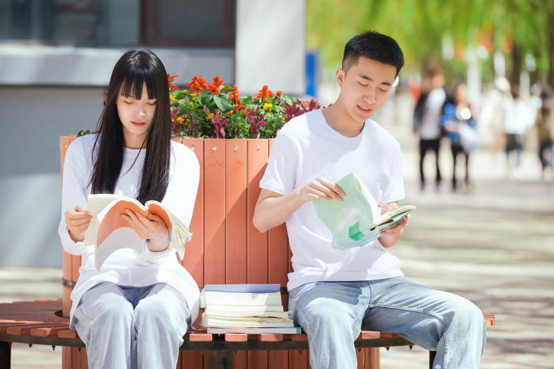 户外校园里读书学习的大学生图片